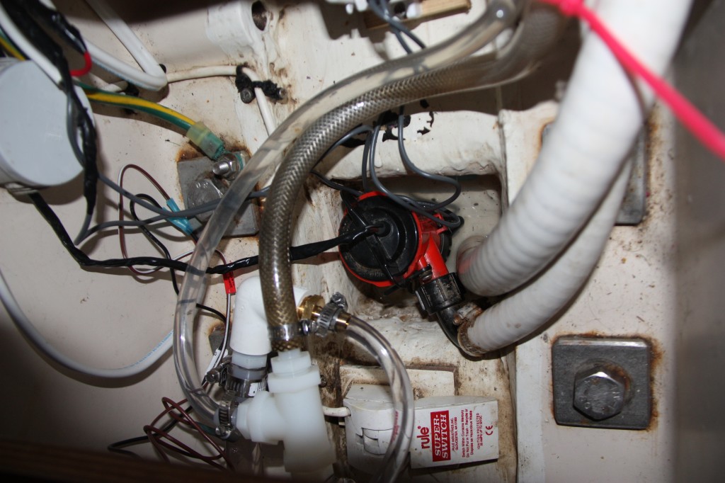 The bilge.  Red pump and float switch at bottom of picture.  The rest of hoses and wires are for the high water alarm, the bilge pump, manual bilge pump, shower sump and hot water tank pressure relief.  Simple right ?!?