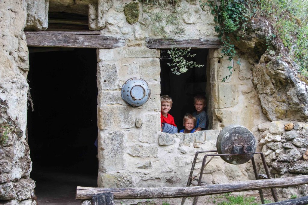 Peasant boys, peeking out the window of their cave home.